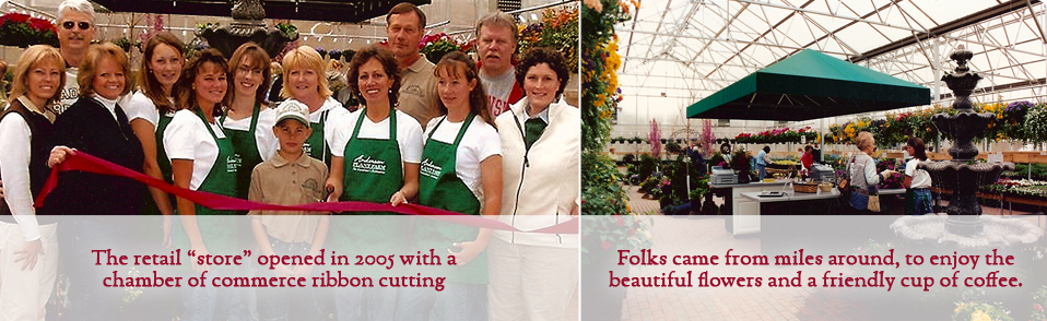 A group of people in green aprons are standing in front of a greenhouse.