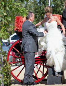 Father helping the bride get down from the vehicle