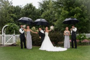 Bride and groom with other couple holding umbrellas