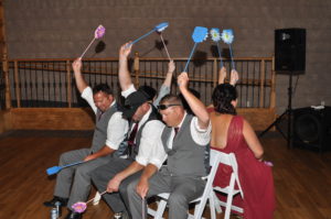 Group of men and women holding flowers fixed to a stick