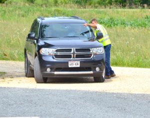 A person showing the way to the person in the car