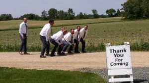 Group of men in white shirt on display