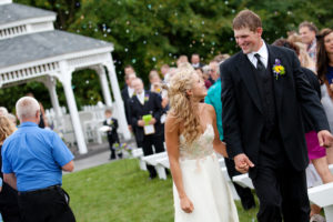 A bride and groom walking down the aisle.