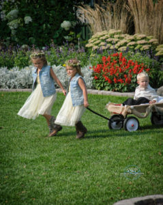 Two girls pulling a toddler on the vehicle