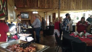 A group of people standing around a buffet table.