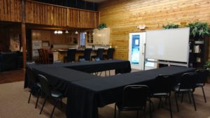 A room with a table and chairs set up for a meeting.