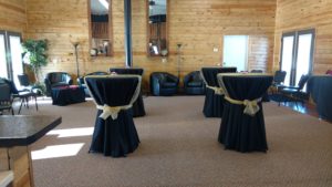 A room with tables and chairs covered in black cloths.