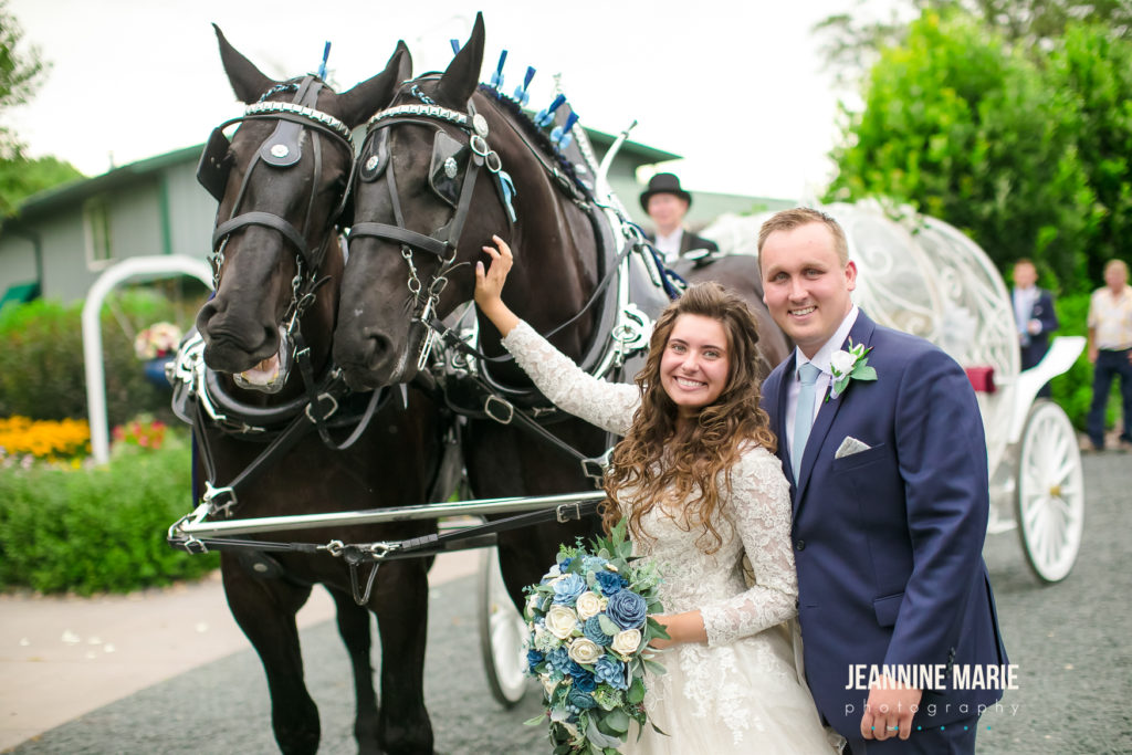 Bride and groom taking a picture with horses