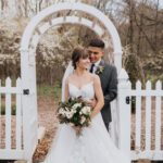 Bride holding flowers and groom holding her