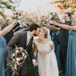 Bride and groom kissing with people behind