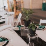 A black and green table setting at a wedding reception.