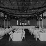 A black and white photo of a wedding reception in a barn.