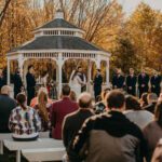 A wedding ceremony at a gazebo in the fall.