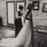 Black and white photo of a bride getting ready in a cabin.