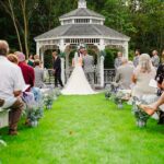 A bride and groom standing in front of a gazebo.