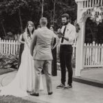 A bride and groom exchange vows in front of a gazebo.