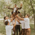 Groom throwing his groomsmen in the air.