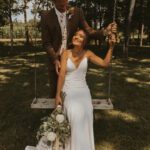 Bride and groom posing sitting on the swing