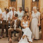 Bride and groom sitting with people behind