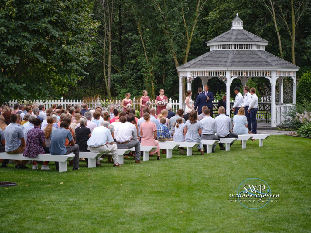 A group of people gathered in front of a gazebo.