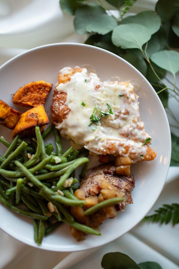 A plate with chicken, green beans and potatoes.